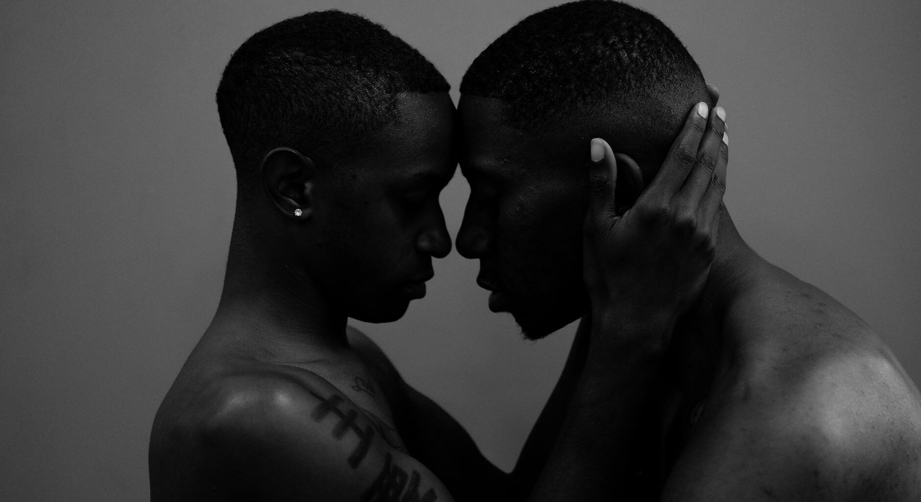 grayscale photo of woman holding man head