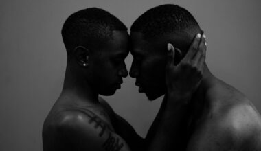 grayscale photo of woman holding man head
