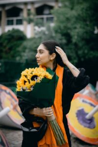 woman holding sunflowers outdoors in iran