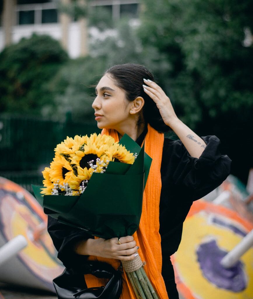 woman holding sunflowers outdoors in iran