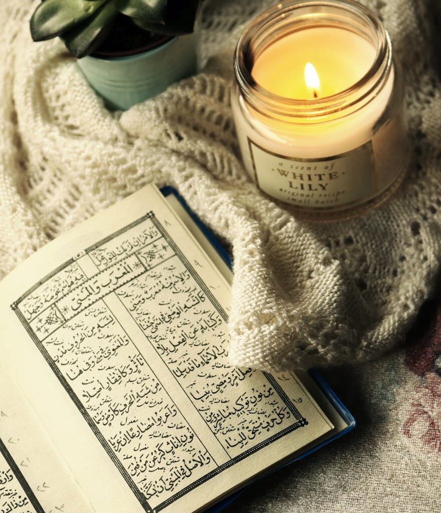photo of quran beside lighted candle