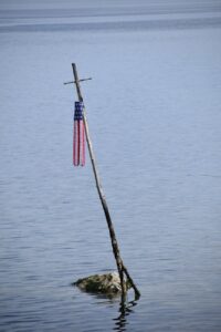 american flag on cross in water