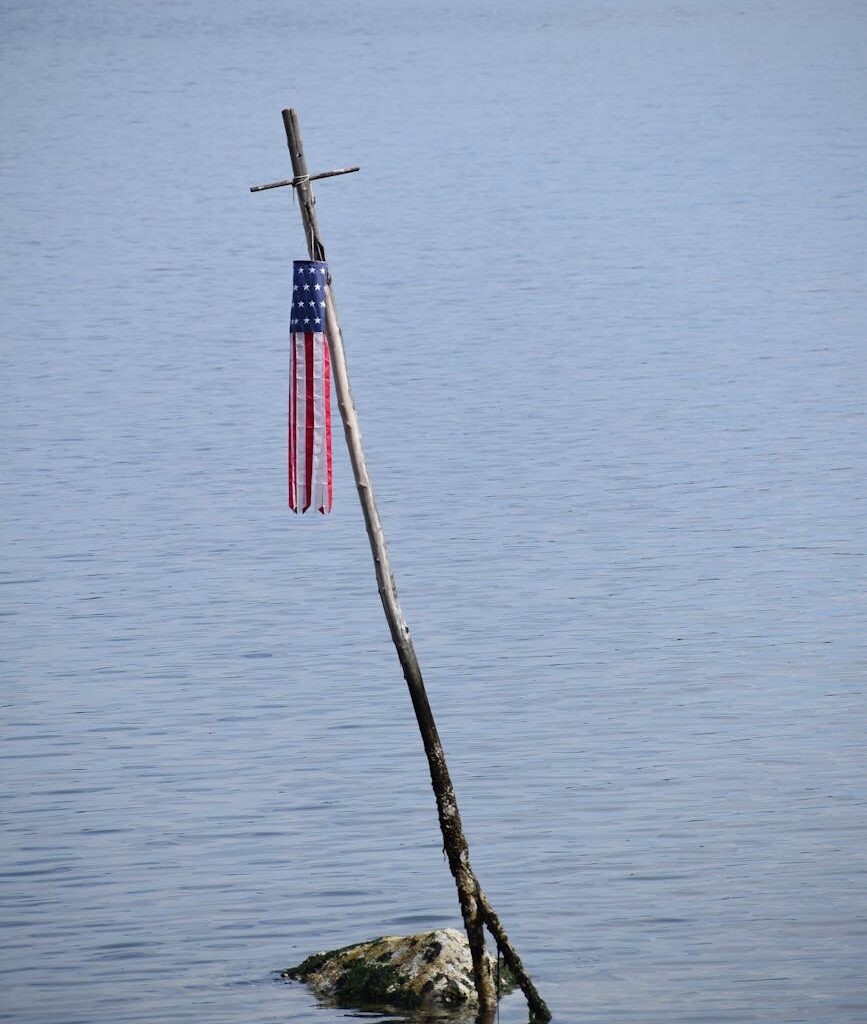 american flag on cross in water