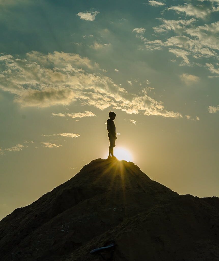 silhouette of a man standing on a mountain