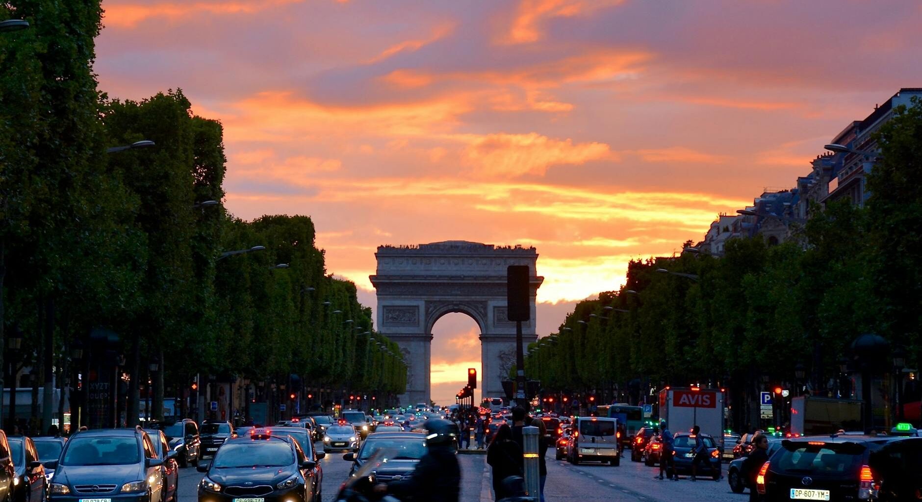 crowded street with cars along arc de triomphe
