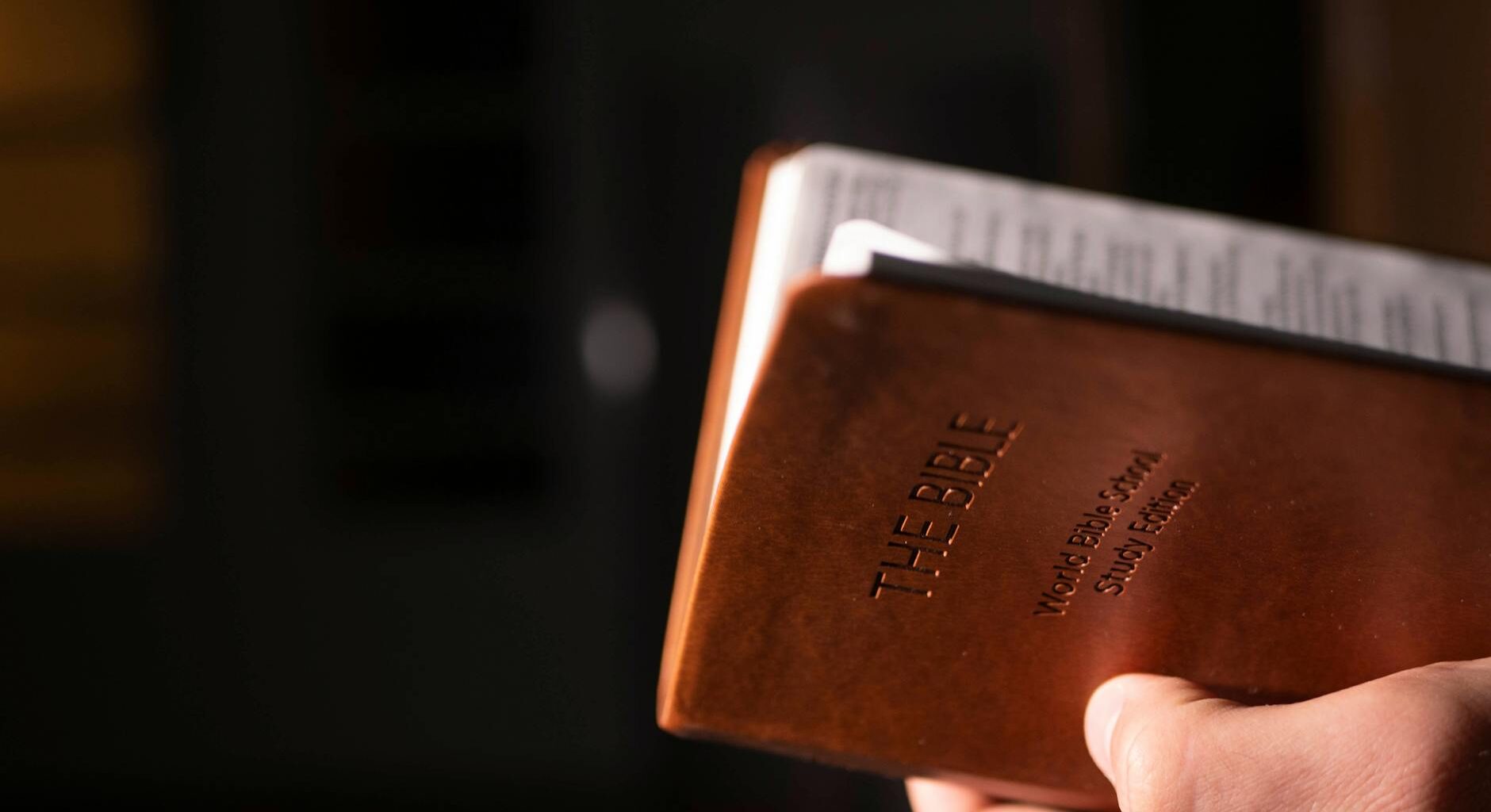 a person holding brown bible