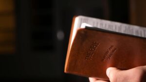 a person holding brown bible