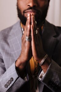 man in gray blazer with hands clasped