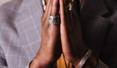 man in gray blazer with hands clasped