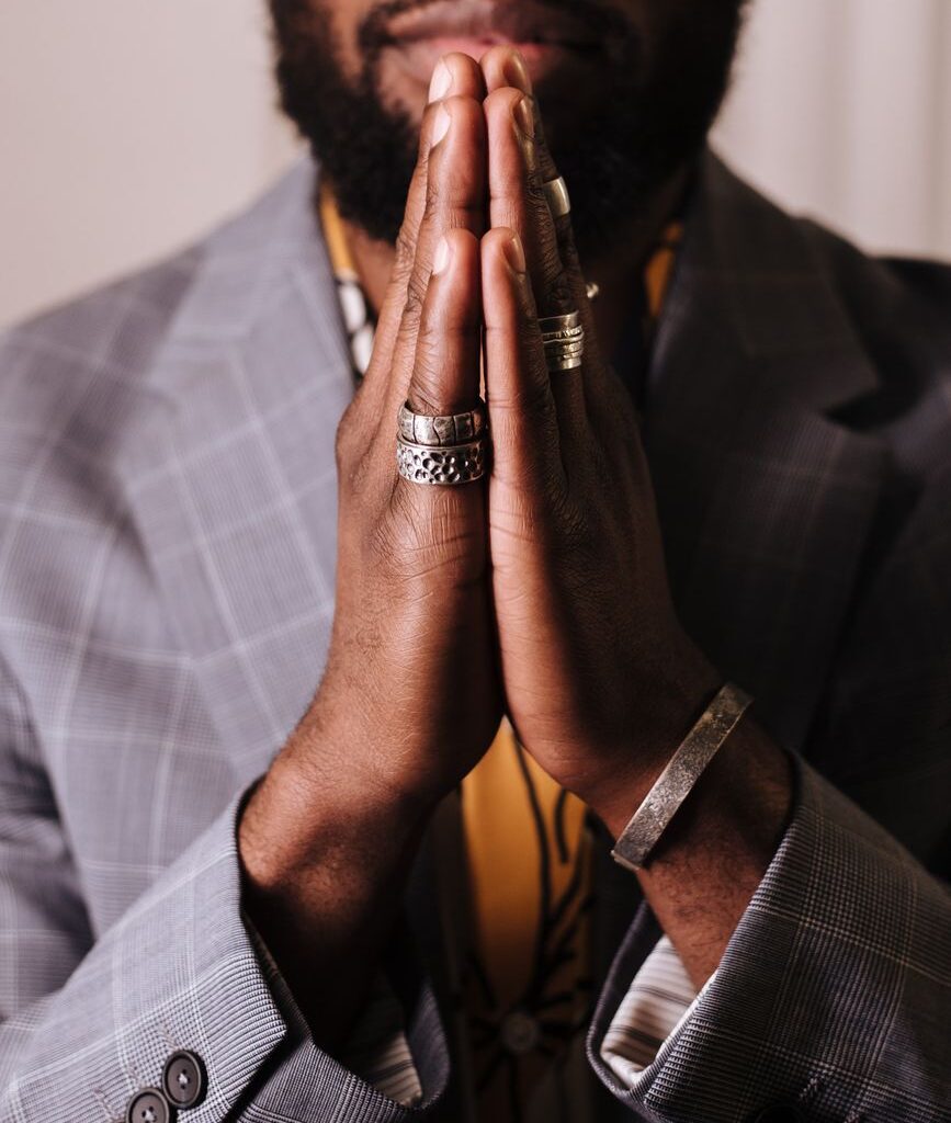 man in gray blazer with hands clasped