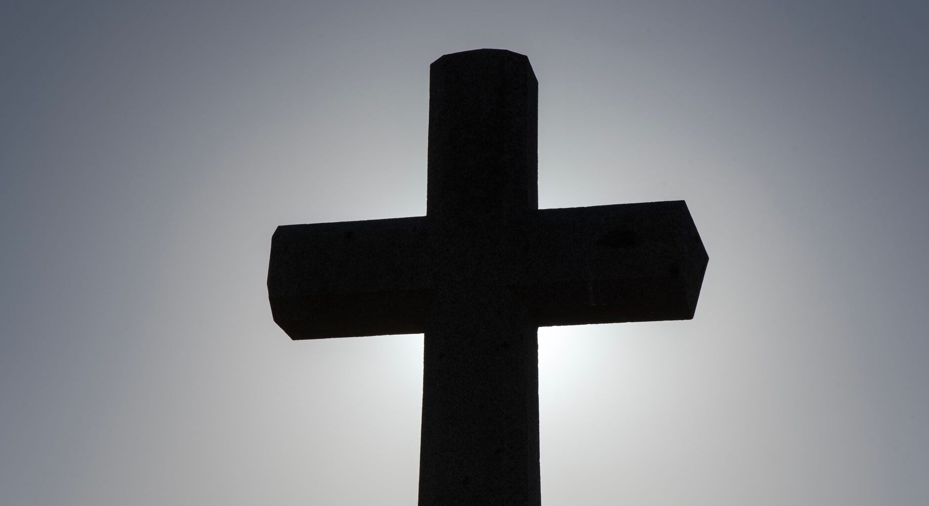 silhouette of a cross against the sky