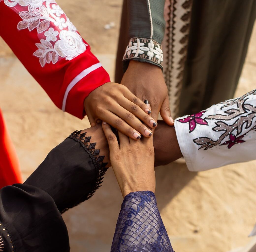 diverse hands joined in solidarity outdoors