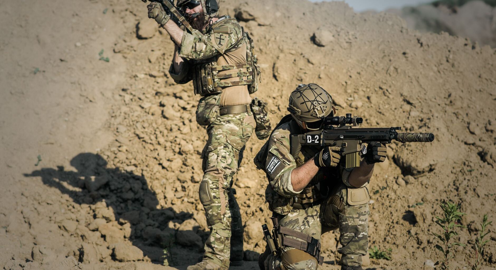 two men in army uniforms with guns