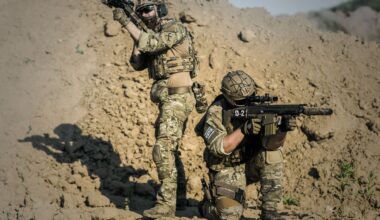 two men in army uniforms with guns